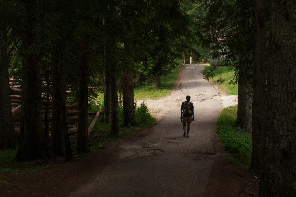 A man walking down a road with multiple paths available